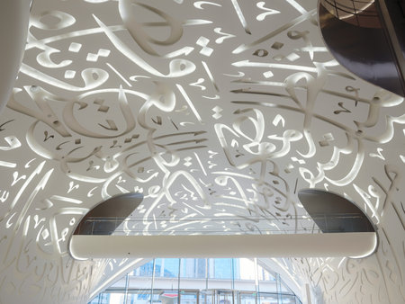 25 March 2023, Dubai, UAE: Museum of the future. Sunset time view. Unique close up perspective. urban background. tourist trip to futuristic Dubai, entrance hall interior with spiral stairs and touristsのeditorial素材