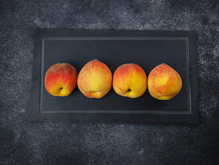 Harvest of peaches for food or juice. fresh organic fruit, vegan food. Large peaches on dark table background, selective focus.の写真素材