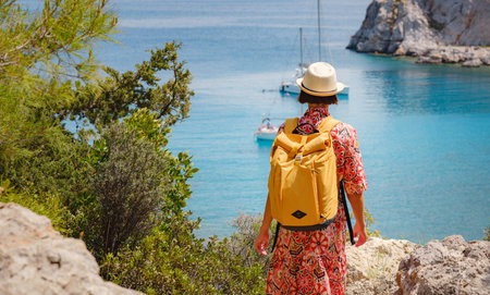 Asian woman in hat look on views of azure Bay in Mediterranean sea. Travel and vacation concept....