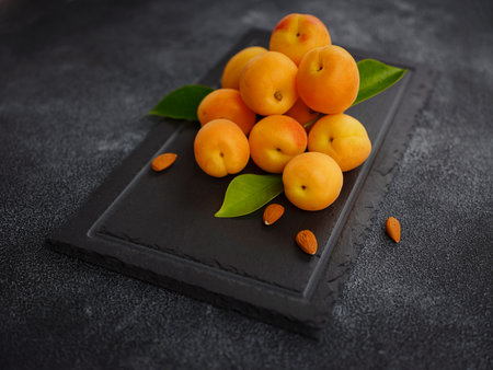 Delicious ripe Fresh juicy apricots on black background, close-up. Selection of healthy vegetarian food, detox or diet concept.の写真素材