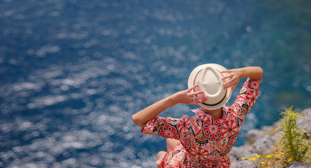 Nice Happy Female Enjoying Sunny Day on Greek Islands. Travel to Greece, Mediterranean islands outside tourist season. Enjoying life and looking at the sea. Turquoise sea background.の写真素材