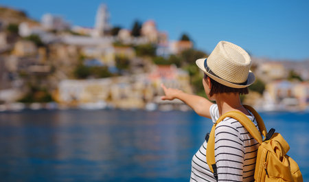 Nice asian Happy Female with backpack Enjoying her holidays on Symi Islands. View of port Symi or...