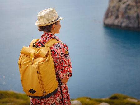 Asian woman in hat look on views of azure Bay in Mediterranean sea. Travel and vacation concept....