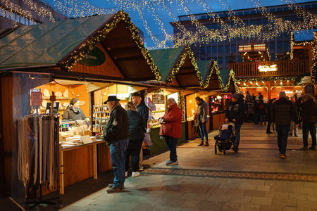 Essen. GERMANY. 13 DECEMBER 2022. The Christmas market in Germany. Celebrating Xmas holidays. Lights, carousel, small houses at the market in the city center with amazing food selection.のeditorial素材