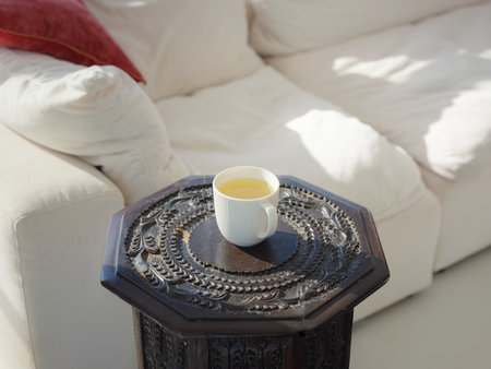 cup of tea on small table. tea in the morning at house. smiling at peace and tea drink to wake up to start day with positive joyful thoughtsの写真素材