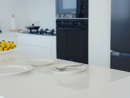 home work in white modern kitchen. plate on table in morning time before breakfastの写真素材