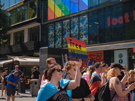 Prague, Czech Republic - August 12, 2023: Pride month in old city center. happy people with rainbow symbols holding sign Free Hugsのeditorial素材