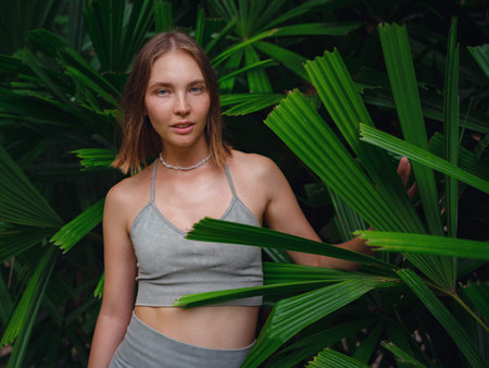 Portrait of a beautiful woman in tropical jungle. tanned female stands in jungle among exotic plants. Thailand, Crabiの写真素材