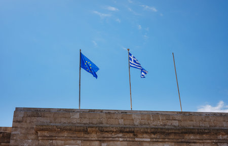 View of Greek and EU flag waving in air serene Mediterranean vibe. beautiful Greek islands series....