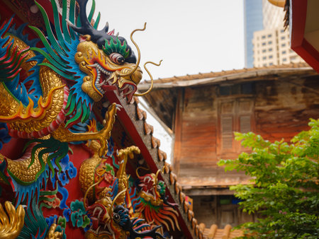Female hand touches a colorful dragon sculpture on the grounds of a temple in Bangkok.の写真素材