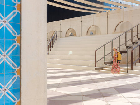 Young woman exploring Qasr Al Hosn Park in Abu Dhabi. Surrounded by lush greenery and historical landmarks, she enjoys the serene atmosphere and Emirati heritage in the heart of the city.の写真素材