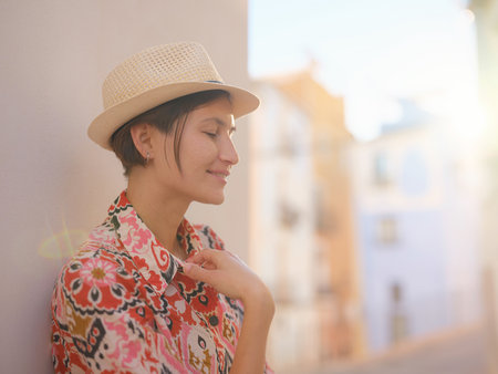 Woman in dress strolls through colorful streets of Spanish coastal town of La Vila Joiosa or Villajoyosa. sunny winter highlights atmosphere charm of Mediterranean architecture and quiet seaside lifeの写真素材