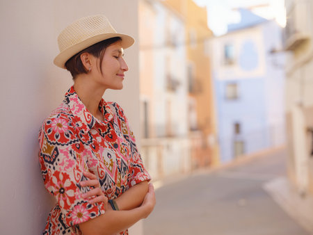 Woman in dress strolls through colorful streets of Spanish coastal town of La Vila Joiosa or Villajoyosa. sunny winter highlights atmosphere charm of Mediterranean architecture and quiet seaside lifeの写真素材