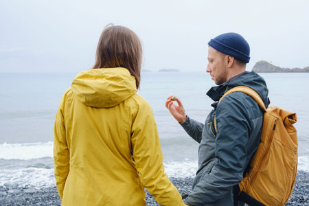 Couple enjoys Turkish coastline. Sitting on stones, watching sea waves, relaxing together, slow...