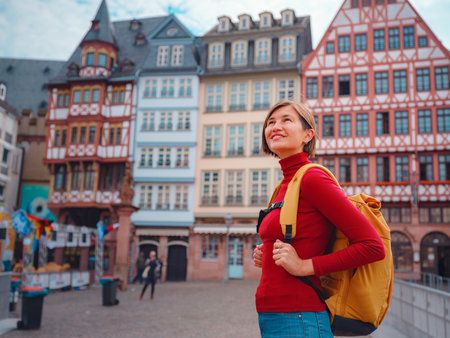 Tourist woman strolls through old town of Frankfurt, exploring its historic streets, beautiful architecture, and cultural landmarks, enjoying vibrant atmosphere of citys past.の写真素材
