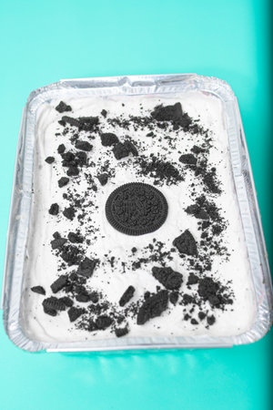 Sponge cake with black and white crumbs on a blue backgroundの写真素材