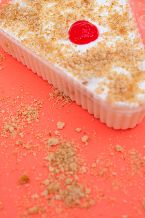 Cake with cream and red cherry on a red background. Selective focus.の写真素材