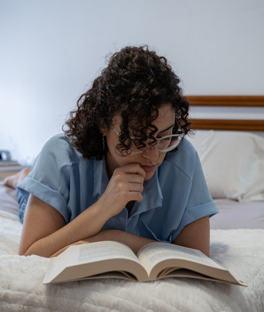 Beautiful woman reads a book on bedの写真素材