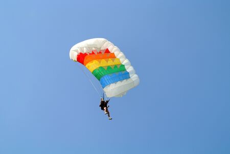 Parachuter skydiving with colourful parachute in rainbow colours on parachuting cupのeditorial素材
