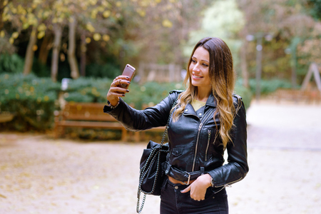 Happy beatiful woman taking selfie in parkの写真素材