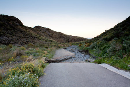 Road ends abruptly into a dry water streamの写真素材