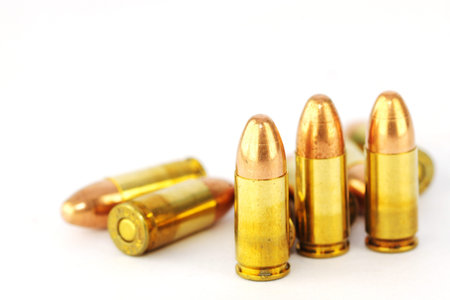 Live 9mm pistol round against white 
