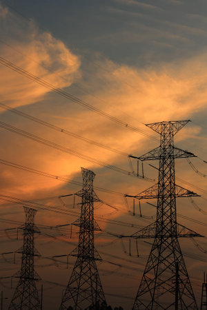 High voltage power pylons in sunset scene twilight