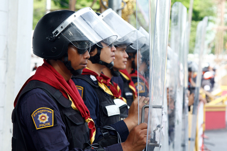BANGKOK - NOV 9: Riot police stand guard near parliament during anti-government rally on Nov 9, 2013 in Bangkok, Thailand. Protests surrounding an amnesty bill のeditorial素材