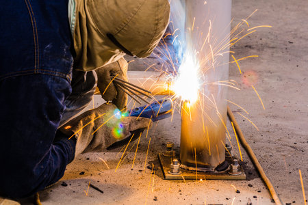 Welder working a welding metal with protective mask and sparks