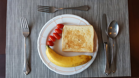 Simple breakfast with bread, banana and tomato.