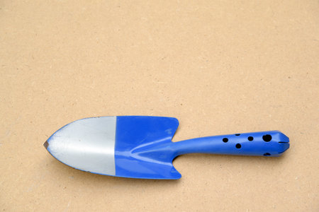 Small blue shovel There are traces of use until the paint scrapes on a brown background.の写真素材