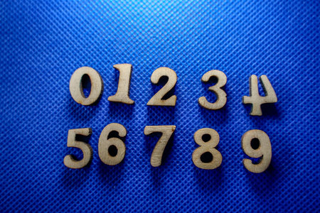 Numbers on a blue background. Numbers 0 to 9 made of wooden letters.