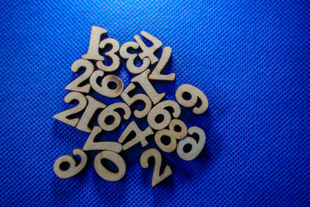 Wooden numbers on a blue background. Numbers from zero to nine.