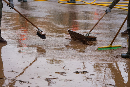 Cleaning the streets with water and brushes, soldiers and firefighters, all united, clean the streets and sidewalks of the towns affected by Dana de Valenciaの写真素材