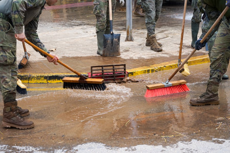 Cleaning the streets with water and brushes, soldiers and firefighters, all united, clean the streets and sidewalks of the towns affected by Dana de Valenciaの写真素材