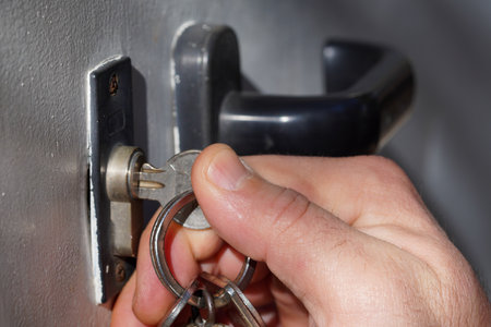 Close-up of a man's hand opening a safe door.の写真素材