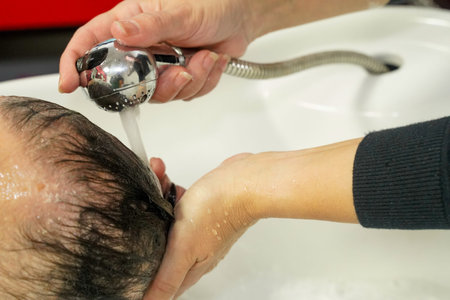 Hairdresser washes a man's hair