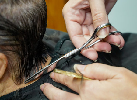 Hairdresser cuts the hair of a woman in a beauty salonの写真素材