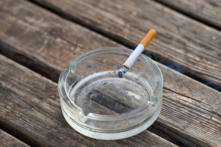 cigar in ashtray on a wooden slat table