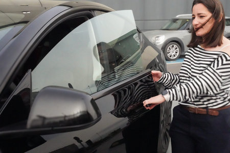 Woman opening the door of her black car to leave