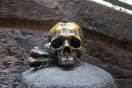 Traditional sculpture of a human skull, on the door of a church, in the narrow streets of the historic center of the city of Naples, where people leave flowersの写真素材