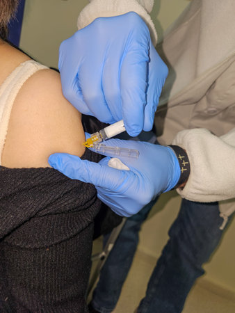 A nurse pinches a woman's arm to administer the seasonal flu vaccine.