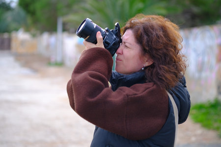 Portrait of a middle-aged woman with a camera in her handsの写真素材