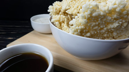 Rengginang or Chips made from Traditional Glutinous Rice from Indonesia placed in a white bowl against a black wooden table background.の写真素材