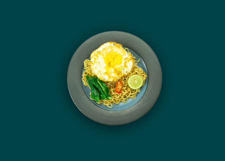 Indonesian Mie Goreng or Fried Noodle with egg traditional Indonesian or Chinese food with mustard greensの写真素材