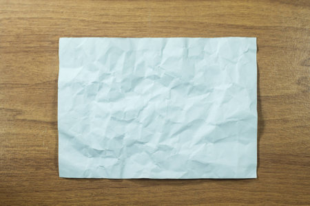 Crumpled paper on wood wallの写真素材