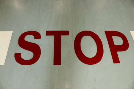 stop sign painted on a asphalt road surfaceの写真素材