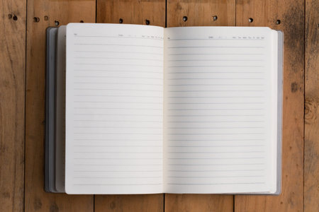 Top view of open note book on wooden backgroundの写真素材