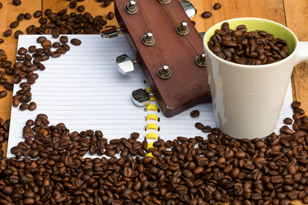 coffee beans in cup with guitar and beans on blank notebook for bの写真素材