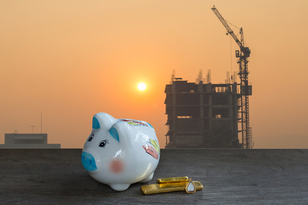 Housing industry mortgage plan and residential tax saving strategy. Piggy bank isolated outside home on background.の写真素材